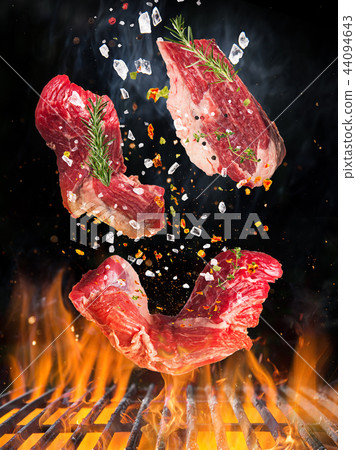 Raw beef steak on the grill with flames 44094643