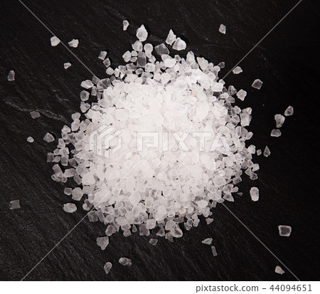 White diamond coarse grain salt heap on black stone background. 44094651