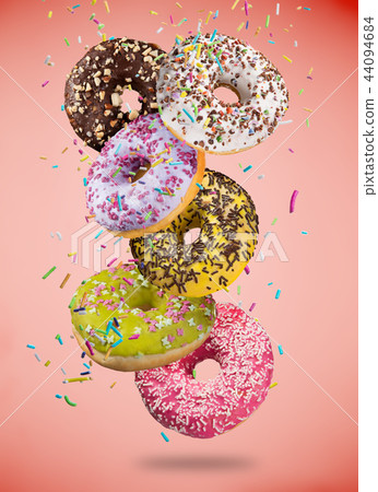 Tasty doughnuts in motion falling on pastel blue background. 44094684
