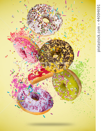 Tasty doughnuts in motion falling on pastel blue background. 44094691