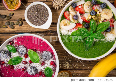 Smoothie bowl with fresh berries, nuts, seeds, fruit and vegetables. Smoothie bowl with fresh berries, nuts, seeds, fruit and vegetables. 44095020