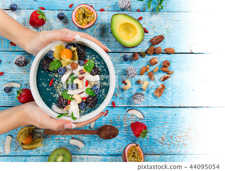 Smoothie bowl with fresh berries, nuts, seeds, fruit and vegetables. Smoothie bowl with fresh berries, nuts, seeds, fruit and vegetables. 44095054