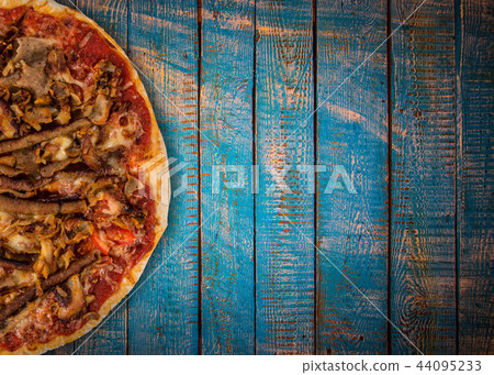 Tasty pizza with sucuk salamy on vintage wooden table. Tasty pizza with sucuk salamy on vintage wooden table. 44095233