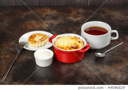 Baked omelet with golden crust in bowl with tea Baked omelet with golden crust in bowl with tea 44096829