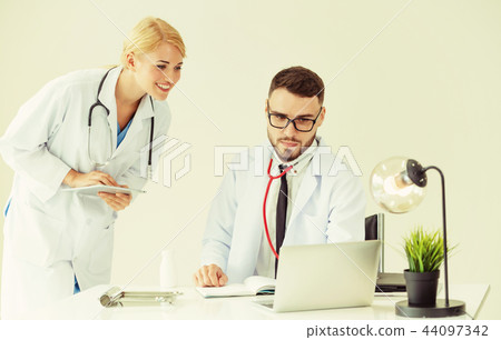 Doctor at hospital works on computer with partner. Doctor at hospital works on computer with partner. 44097342