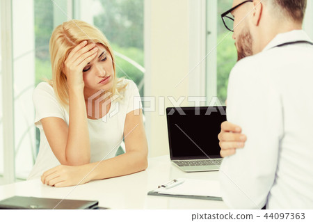 Male Doctor and Female Patient in Hospital Office 44097363