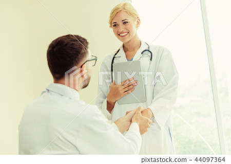 Doctor at hospital shakes hand with another doctor 44097364