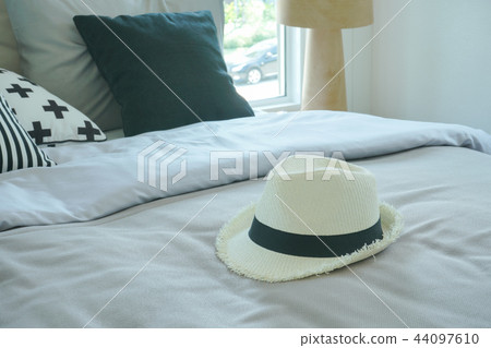 Stylish bedroom with hat at the center of bed Stylish bedroom with hat at the center of bed 44097610