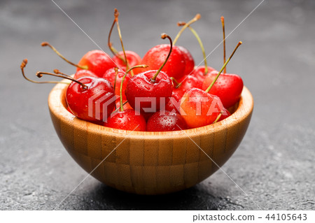 Photo of red cherry in wooden cup Photo of red cherry in wooden cup 44105643