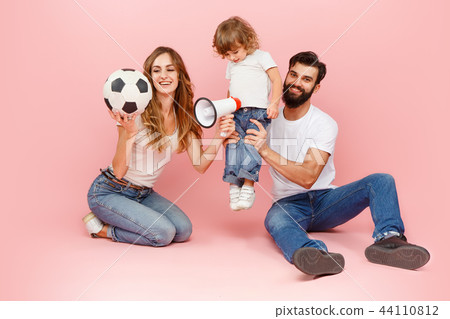 happy father and son playing together with soccer ball on pink 44110812