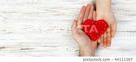 help, Heart in Hand on wood background. 44111367