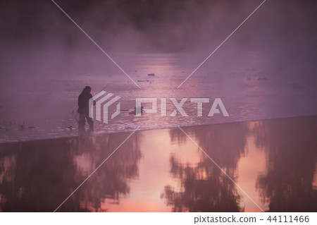 Fisherman holding fishing rod, standing in river 44111466