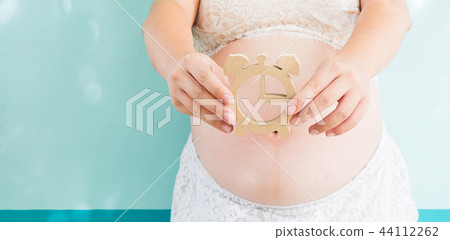 Pregnancy woman holding wooden clock Pregnancy woman holding wooden clock 44112262