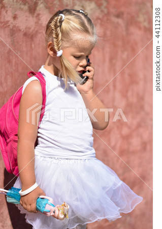 Sad girl with a backpack calling on  mobile phone Sad girl with a backpack calling on  mobile phone 44112308