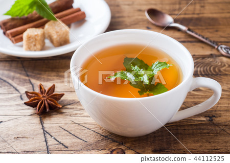 Cup of hot tea with mint and brown sugar Cup of hot tea with mint and brown sugar 44112525