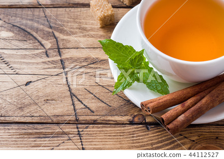 Cup of hot tea with mint and brown sugar Cup of hot tea with mint and brown sugar 44112527