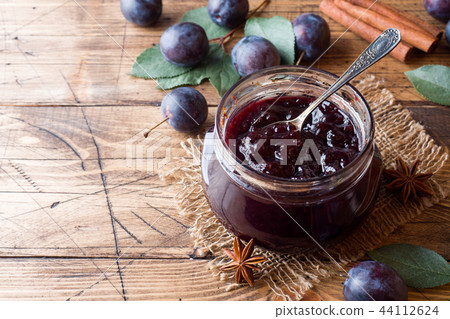 Plum jam in a glass jar. Fresh plum fruit  44112624