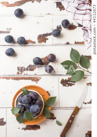 Fresh plum berries on a plate with leaves  44112673