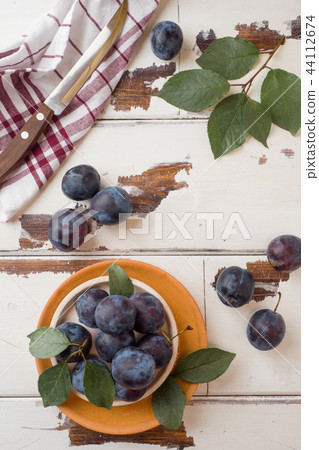 Fresh plum berries on a plate with leaves  44112674