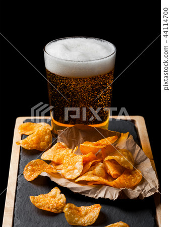 Glass of lager beer with potato crisps snack  44114700