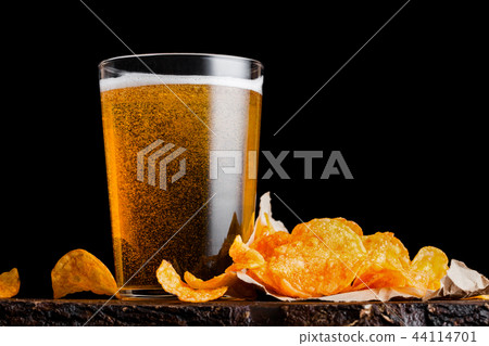 Glass of lager beer with potato crisps snack Glass of lager beer with potato crisps snack 44114701