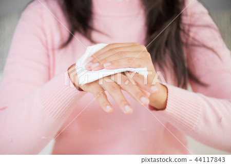 Woman cleaning her hands with a tissue Woman cleaning her hands with a tissue 44117843