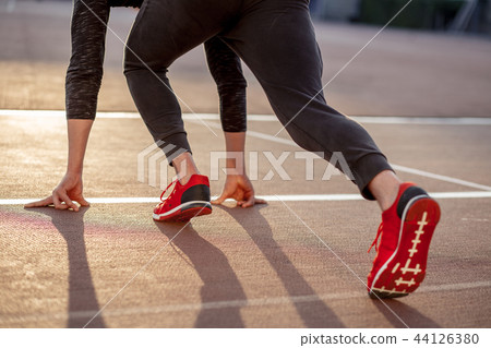 man feet in starting position for running on race track in stadium man feet in starting position for running on race track in stadium 44126380