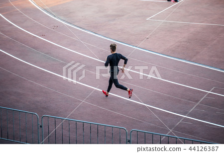 Top view Athlete running on running track. Runner sprinting on red running track in stadium 44126387