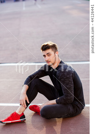 time to rest. man resting after running on track in stadium 44126441