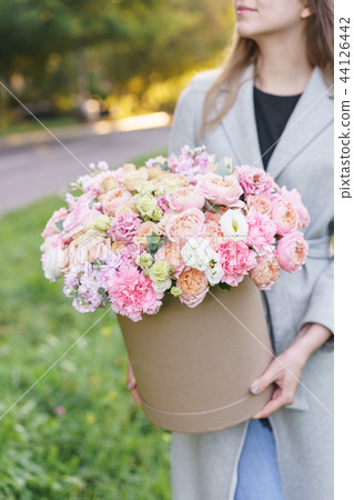 Beautiful spring bouquet in round box. Arrangement with various flowers. The concept of a flower Beautiful spring bouquet in round box. Arrangement with various flowers. The concept of a flower 44126442
