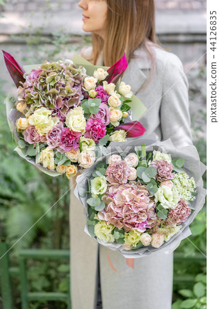 two beautiful spring bouquet. Young girl holding a flowers arrangements with various of colors two beautiful spring bouquet. Young girl holding a flowers arrangements with various of colors 44126835