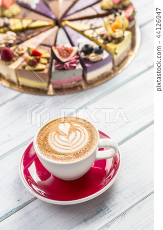 A cup of art coffee cappiciino and mini raw cakes A cup of art coffee cappiciino and mini raw cakes 44126947
