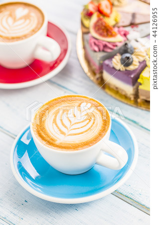 A cup of art coffee cappiciino and mini raw cakes A cup of art coffee cappiciino and mini raw cakes 44126955