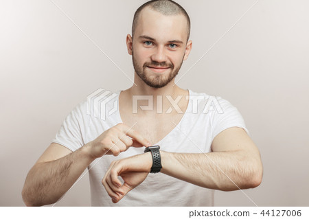 happy, cheerful guy is touching the screen of his smartwatch 44127006