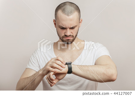 upset, angry athlete with heart rate monitor watch. 44127007