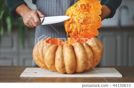 hands of man cutting pumpkin to halloween hands of man cutting pumpkin to halloween 44130633