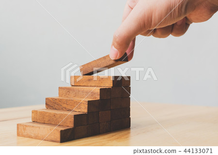 Hand arranging wood block stacking as step stair Hand arranging wood block stacking as step stair 44133071