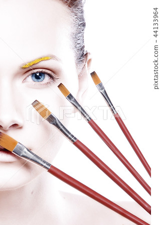 Young woman putting some special effects makeup on face Young woman putting some special effects makeup on face 44133964