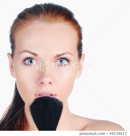Beautiful young girl on spa procedures with tassel near face. 44134611