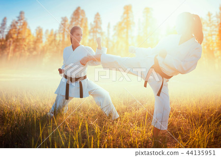 Two female karate in kimono fight in summer field 44135951
