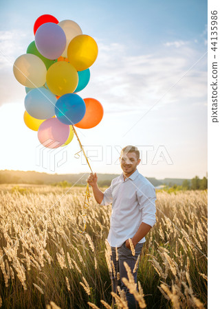 Man walks with bunch of balloons Man walks with bunch of balloons 44135986