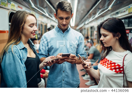 Addict youth using phones in metro, addiction Addict youth using phones in metro, addiction 44136096