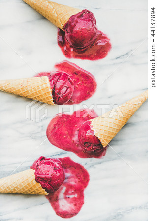 Raspberry sorbet ice-cream scoops in waffle cones, top view Raspberry sorbet ice-cream scoops in waffle cones, top view 44137894