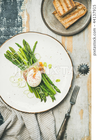Flat-lay of green asparagus, soft-boiled egg , bacon and toasts Flat-lay of green asparagus, soft-boiled egg , bacon and toasts 44137915