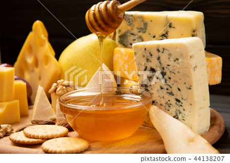 Various types of cheese on a rustic table 44138207