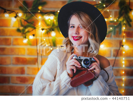 woman with vintage camera and Christmas lights woman with vintage camera and Christmas lights 44140751