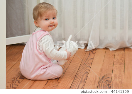 Little girl holding white toy in hands Little girl holding white toy in hands 44141509
