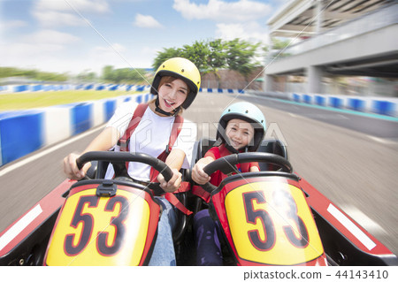 mother and daughter driving go kart on the track mother and daughter driving go kart on the track 44143410