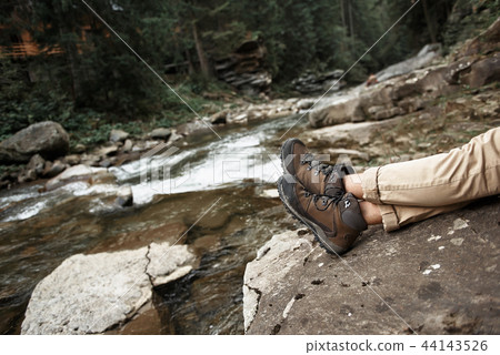 Close view of the feet with mountain river on the background 44143526