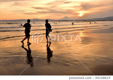 Silhouette of two young people rising up on the sunset beach Silhouette of two young people rising up on the sunset beach 44148624